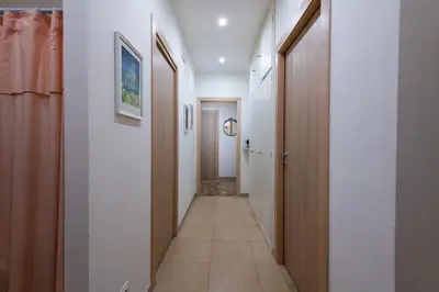 a hallway with wooden doors and a tile floor at Casa Rosa Beige e Blu in Rome