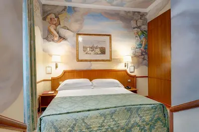 a bedroom with a bed with a painting on the wall at Hotel Amalfi in Rome