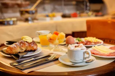 a table with plates of food and a cup of coffee at Hotel Amalfi in Rome