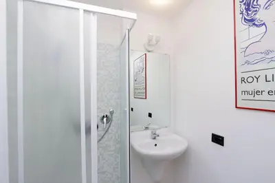 a white bathroom with a sink and a shower at RomeAsYouLike-Colosseo Experience45 in Rome