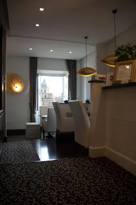 a dining room with white chairs and a table and a window at Relais La Maison De Luxe in Rome