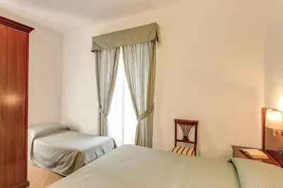 a bedroom with two beds and a window at Hotel Flavio in Rome