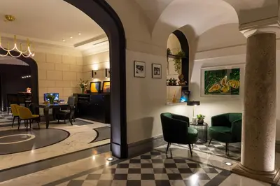 a lobby of a hotel with chairs and a table at Hotel Principe Torlonia in Rome