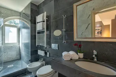a bedroom with a white bed and a red chair at Hotel Principe Torlonia in Rome