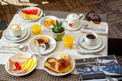 a table with plates of breakfast foods and cups of coffee at Hotel Gioberti in Rome