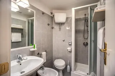 a bathroom with a sink and a toilet and a shower at Hotel Napoleon in Rome