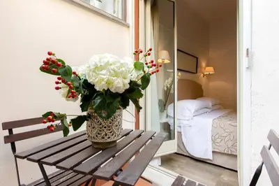 a vase of flowers sitting on a wooden bench at Hotel Modigliani in Rome