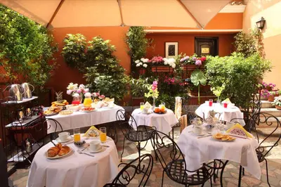 a group of tables with food on them in a courtyard at Hotel Modigliani in Rome