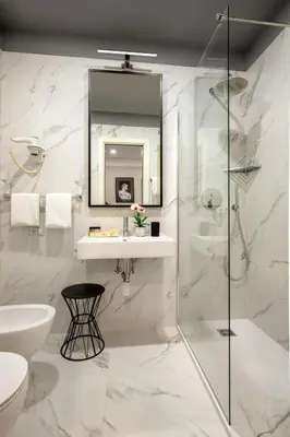 a white bathroom with a sink and a shower at Condotti Boutique Hotel in Rome