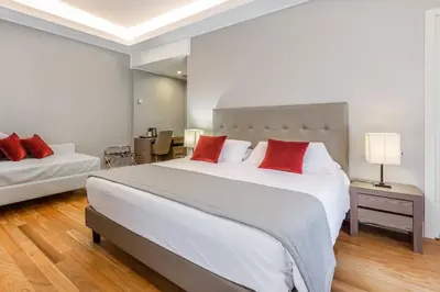 a bedroom with a large white bed with red pillows at Hotel Delle Nazioni in Rome