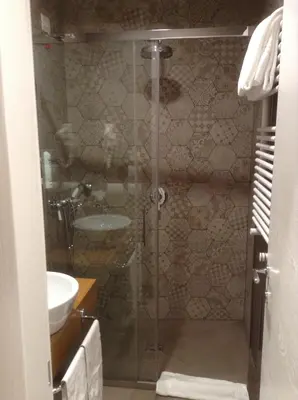 a bathroom with a glass shower with a sink at Hotel Elite in Rome