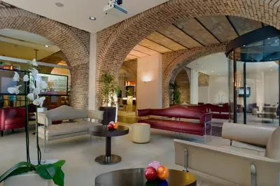 a lobby with couches and tables in a building at Kolbe Hotel Rome in Rome
