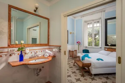 a bathroom with a sink and a bed and a mirror at Hotel Emona Aquaeductus in Rome