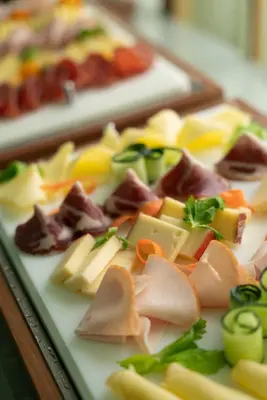 a plate of different types of cheese and vegetables at Hotel Degli Aranci in Rome