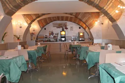 a restaurant with green tables and chairs and a counter at Hotel Dei Mille in Rome
