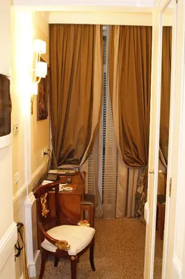 a room with a desk and a chair and curtains at Boutique Hotel Trevi in Rome