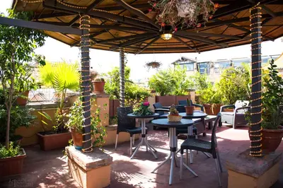 a patio with tables and chairs under an umbrella at Pantheon Inn in Rome
