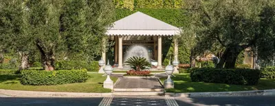 a fountain in the middle of a park with trees at Rome Cavalieri, A Waldorf Astoria Hotel in Rome