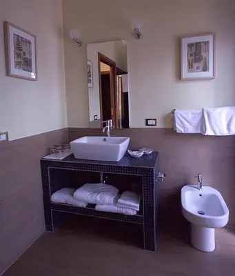 a bathroom with a sink and a toilet and a mirror at Hotel Residence Magnolia in Rome
