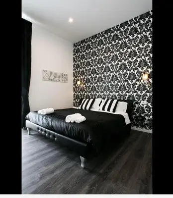 a bedroom with a black bed and a black and white wall at Rome Key Home in Rome