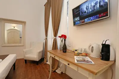 a room with a table and a tv on the wall at Juno Pantheon in Rome