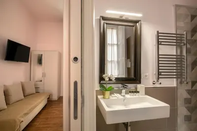 a bathroom with a sink and a mirror and a couch at Juno Pantheon in Rome
