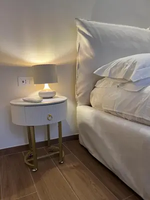 a bedside table with a lamp on it next to a bed at Ascanio Twenty Six in Rome