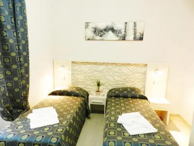 a hotel room with two beds and a table at Vatican Rome in Rome