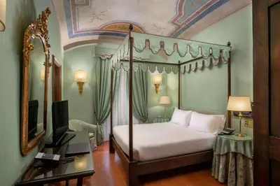 a bedroom with a canopy bed and a television at Hotel Canada, BW Premier Collection in Rome