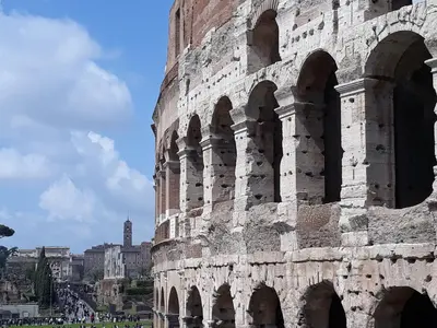 a large brick building with arches on the side at 2 Be Home Colosseo in Rome