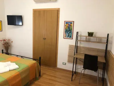 a bedroom with a bed and a desk and a chair at Maison Vaticana in Rome