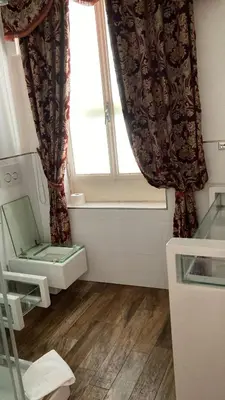 a small room with a window and a wooden floor at D.R.Rome Spanish Luxury Suites in Rome