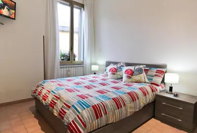 a bedroom with a bed with a colorful bedspread and a window at San Pietro's Home in Rome