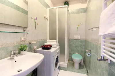 a bathroom with a sink and a washing machine at San Pietro's Home in Rome