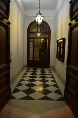 a hallway with a door and a checkered floor at Domus Chiara al Colosseo in Rome