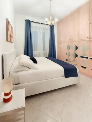 a bedroom with a large bed with blue curtains at Domus Chiara al Colosseo in Rome