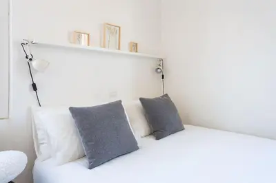 a white couch with two gray pillows on it at Cozy Suite Pigneto in Rome
