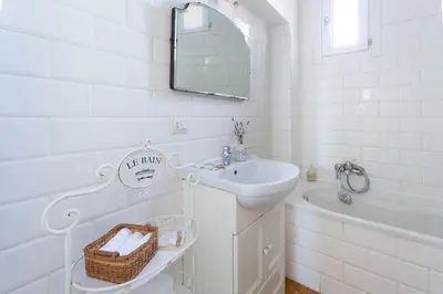a white bathroom with a sink and a bath tub at Cozy Suite Pigneto in Rome