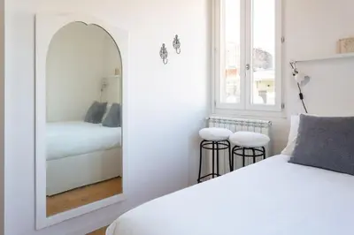a white bedroom with a mirror and a bed at Cozy Suite Pigneto in Rome
