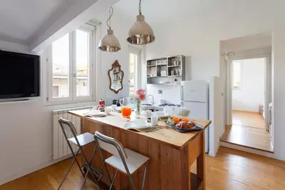 a kitchen with a large wooden island with chairs at Cozy Suite Pigneto in Rome