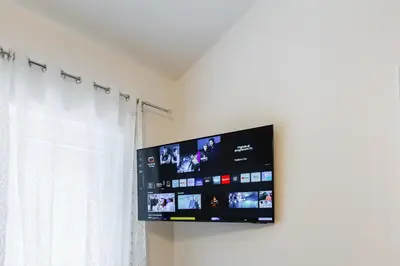 a flat screen tv hanging on a wall next to a window at Vatican 96 Degli Ubaldi Charming Suite with terrace in Rome