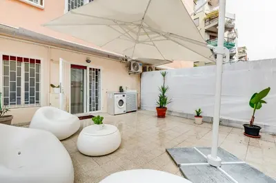 a patio with two white chairs and an umbrella at Vatican 96 Degli Ubaldi Charming Suite with terrace in Rome