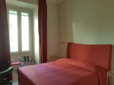 a bedroom with a red bed and a window at Popolo square deluxe flat in Rome