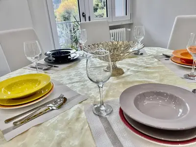 a dining room table with plates and glasses on it at Lussuoso 130 MQ zona Cipro in Rome