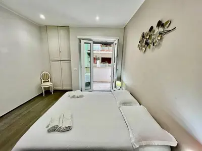 a bedroom with a large white bed with flip flops on it at Lussuoso 130 MQ zona Cipro in Rome