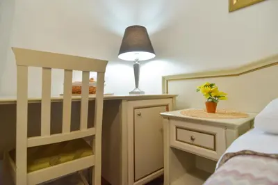 a bedroom with a crib and a table with a lamp at Gisa Rooms in Rome