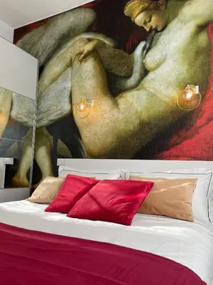 a bedroom with a painting above a bed with red pillows at E&E Guest House in Rome