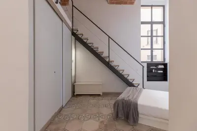 a bedroom with a bed and a staircase at iFlat Trastevere Unique Loft in Rome