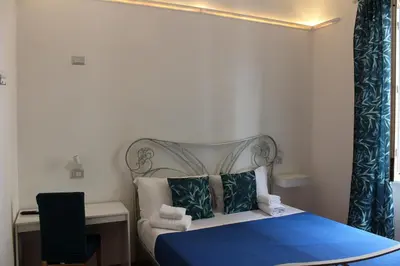 a bedroom with a bed with blue sheets and a blue bedspread at Rooms Piramide in Rome