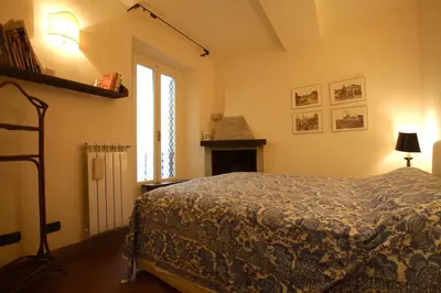 a bedroom with a bed and a fireplace at Pozzuolo Holiday House in Rome